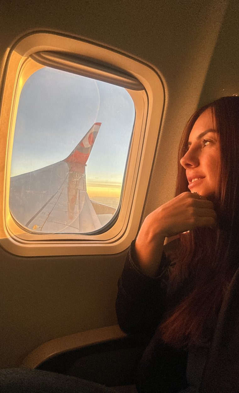 Ana Luísa olhando pela janela do avião